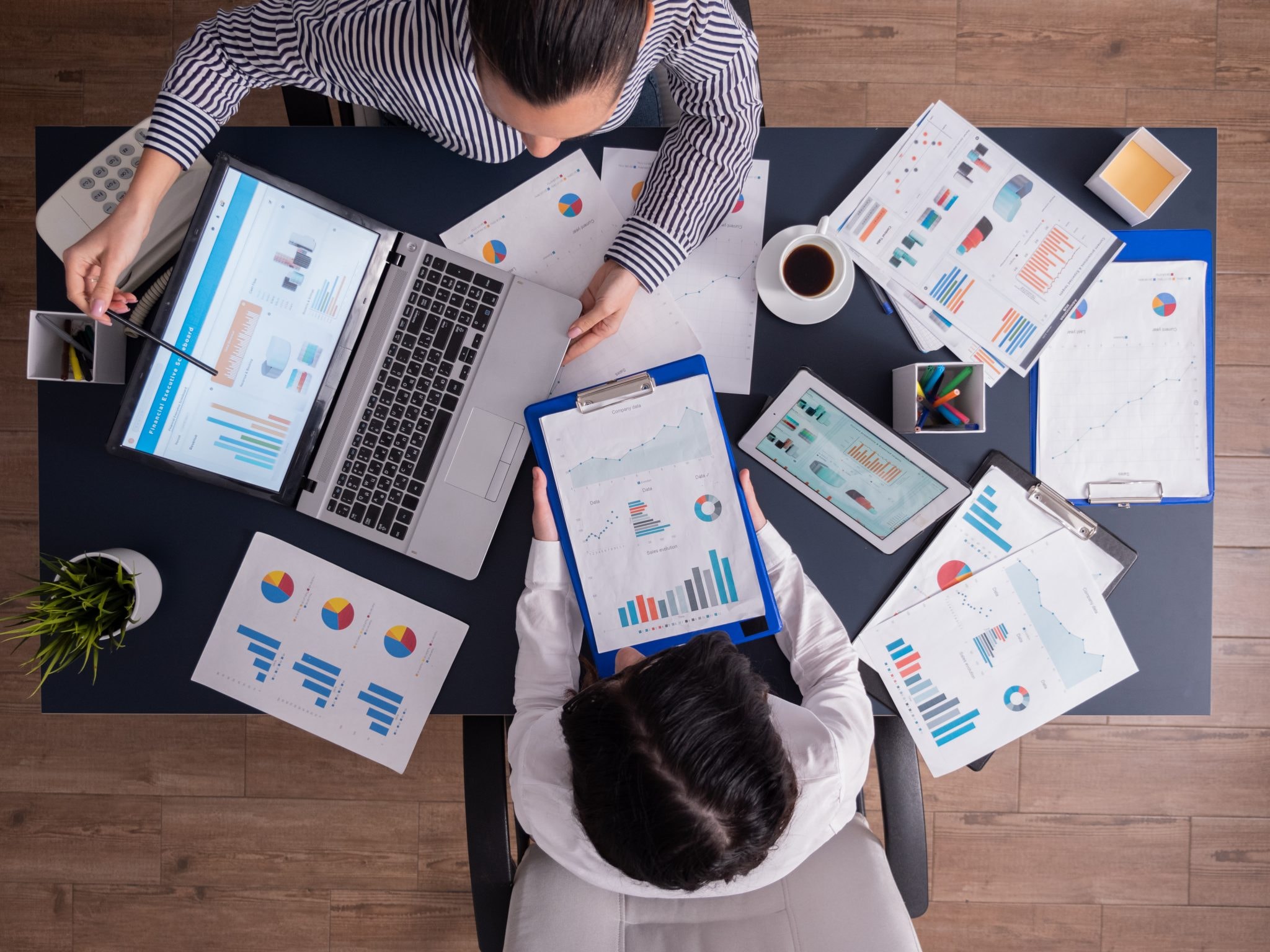 Managers reviewing charts and laptop data in an office